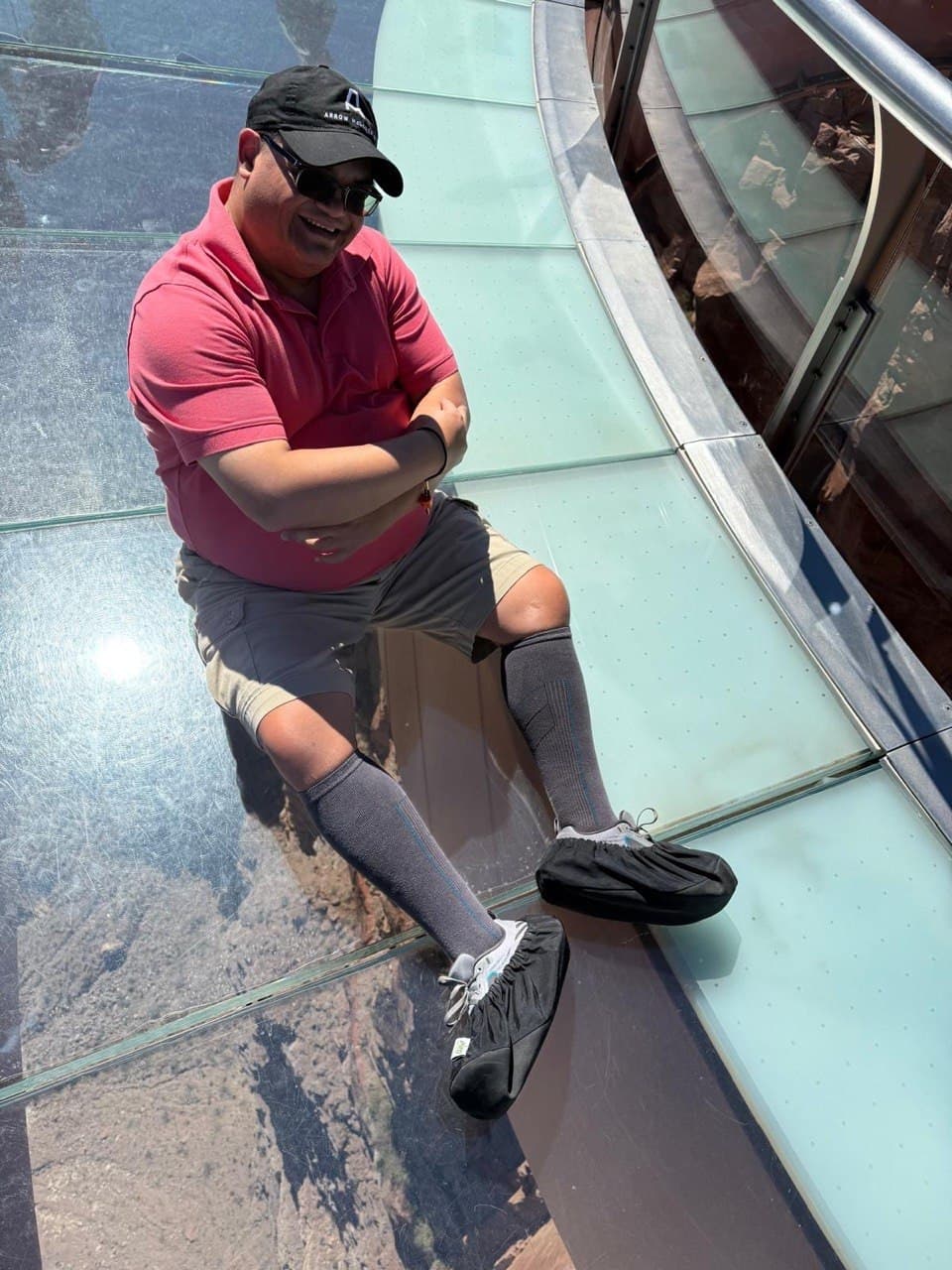 Alejo sitting on the glass floor at the Skywalk