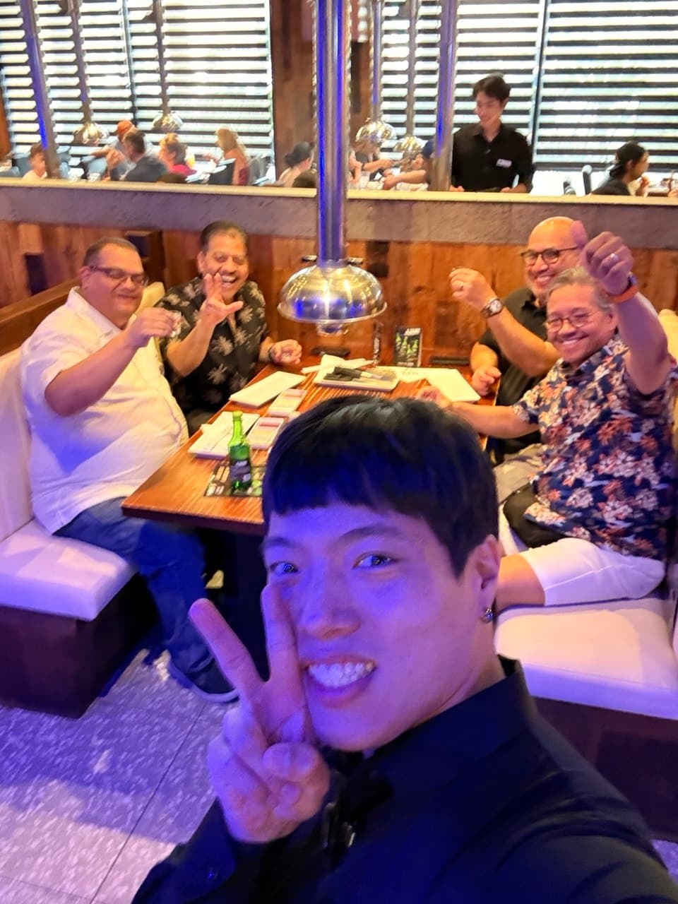 The four friends taking a selfie with the waiter at Gen Korean BBQ