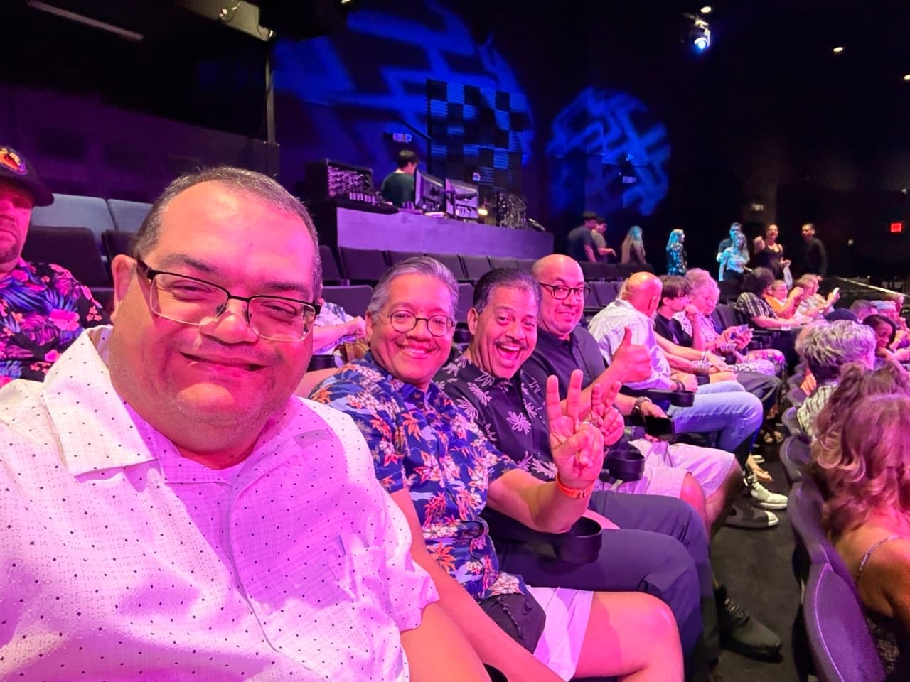 All four friends seated together in the theater